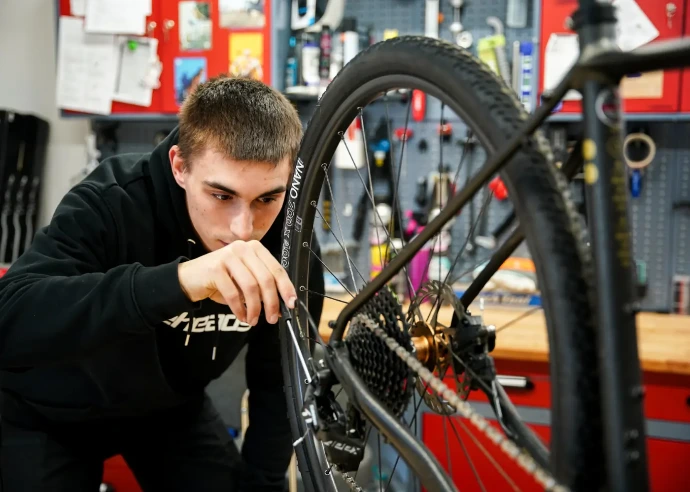 Ein Refresh Mitarbeiter stellt eine Schaltunf an einem Fahrrad ein.