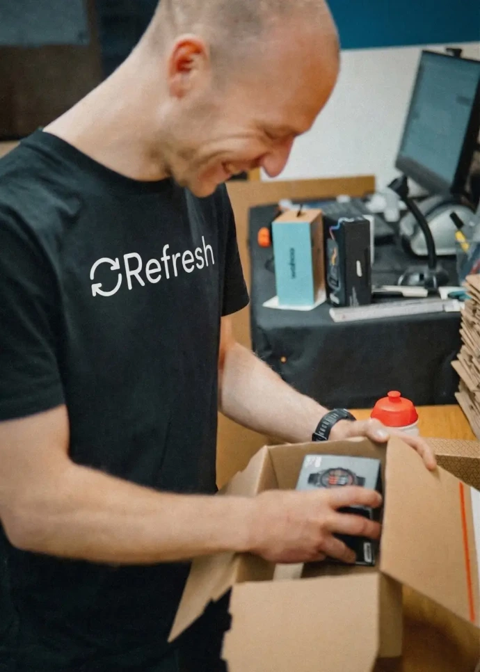 Ein Refresh Mitarbeiter verpackt eine Kundenbestellung.